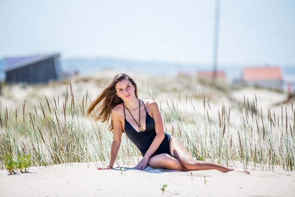 a woman in a bathing suit sitting on the beach