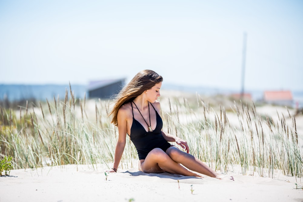 Eine Frau im Badeanzug sitzt am Strand