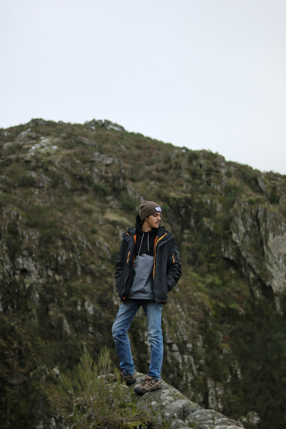 a man standing on top of a rocky hill