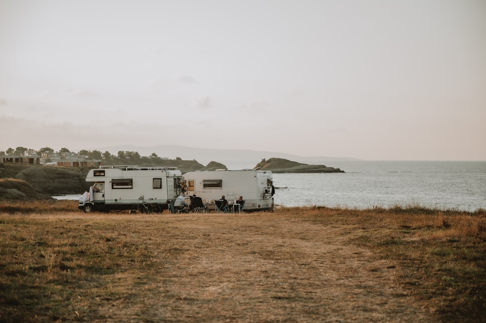 a couple of rvs parked next to a body of water