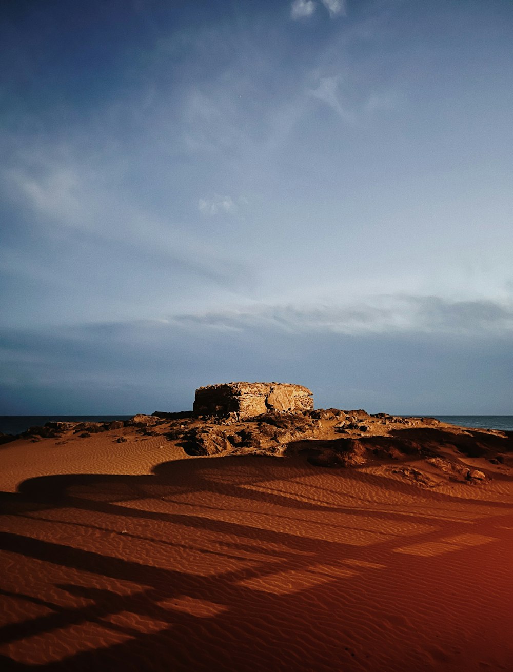 a large rock sitting on top of a sandy beach