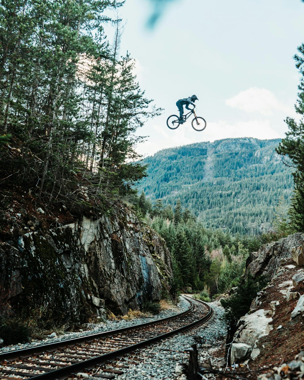 a man flying through the air while riding a bike