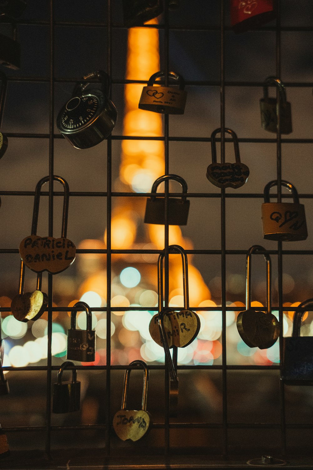 many padlocks are attached to a fence with the eiffel tower in