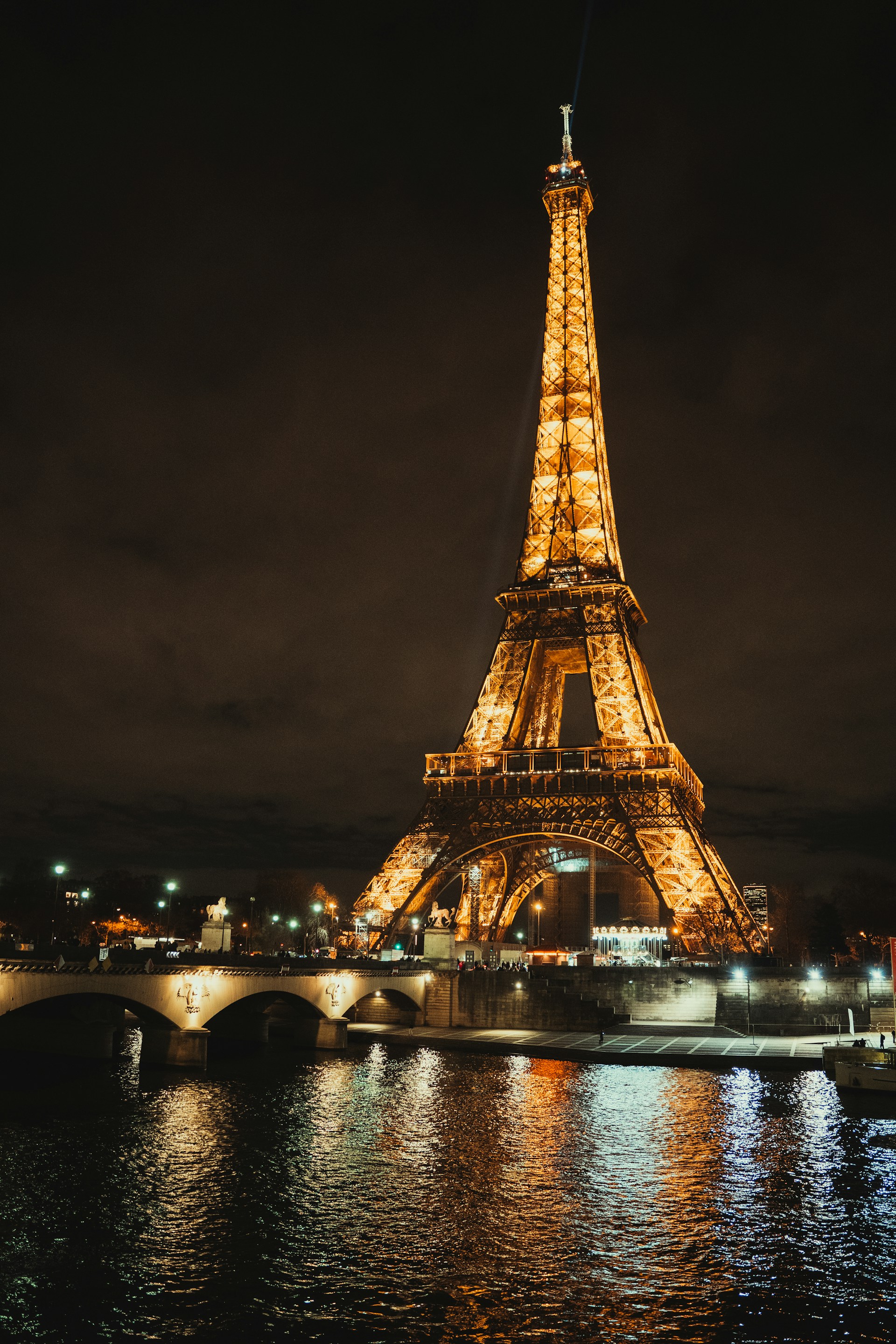 the eiffel tower is lit up at night