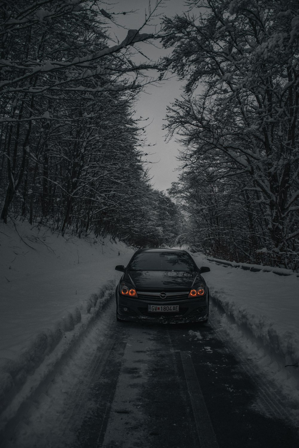 un coche conduciendo por una carretera cubierta de nieve