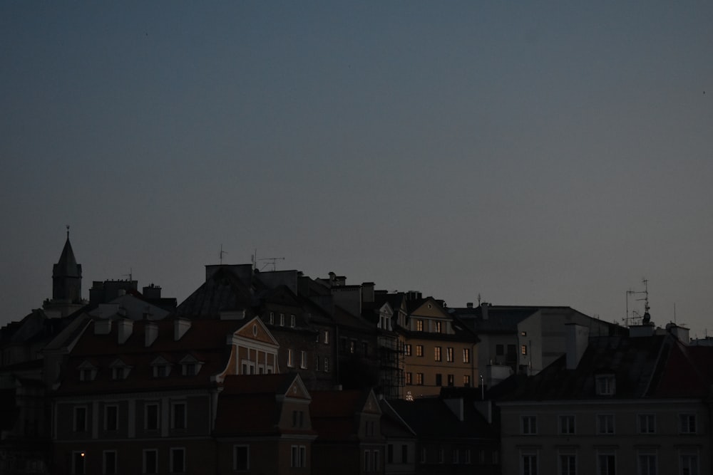 a view of a city at night with a full moon in the sky