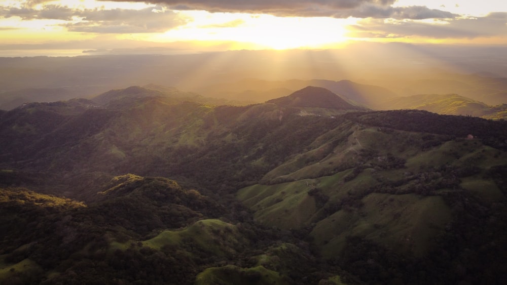 the sun shines through the clouds over the mountains