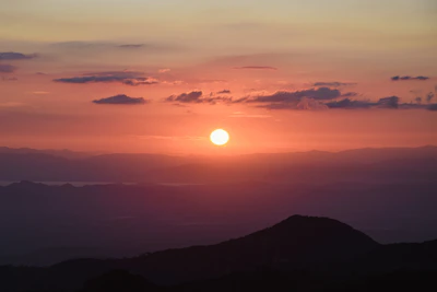 A vibrant sunset casting warm light over Monterrey's iconic Cerro de la Silla.