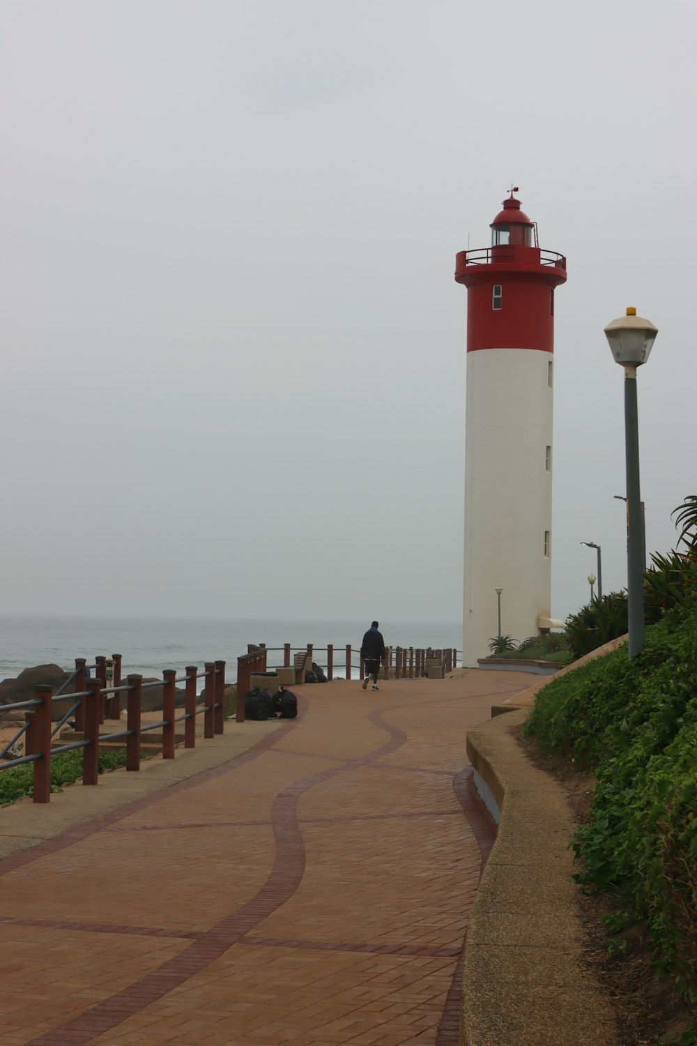 a red and white light house next to the ocean