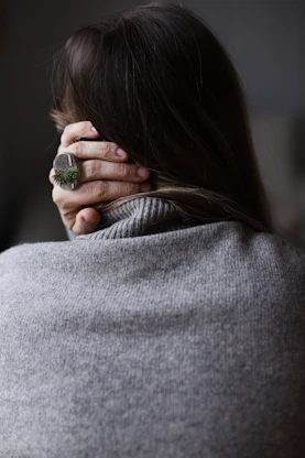 Woman holding the back of her neck representing physical tension and stress from anxiety depression