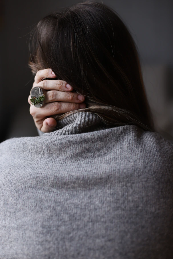 Woman holding the back of her neck representing physical tension and stress from anxiety depression
