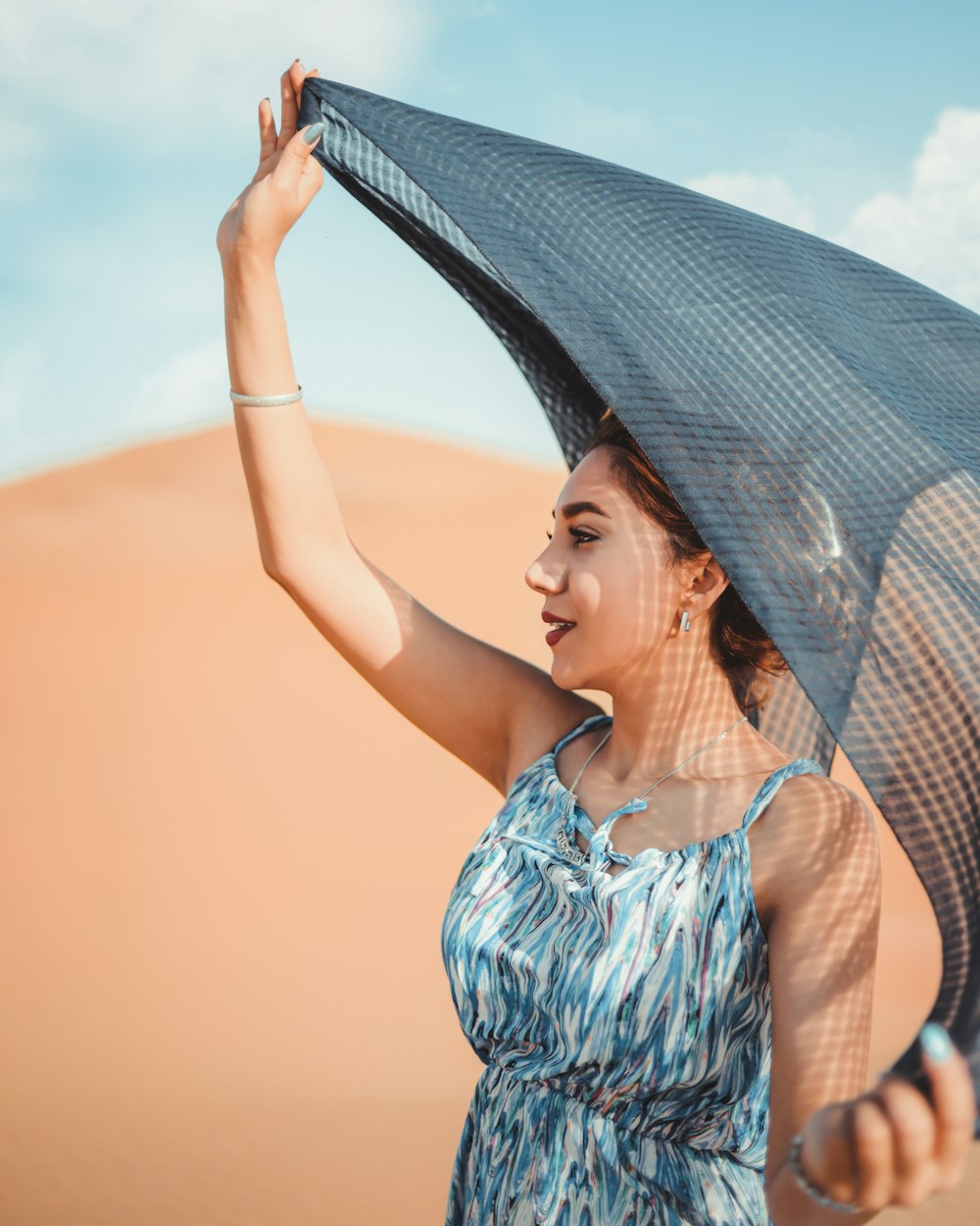 Una donna che tiene un ombrello nel deserto