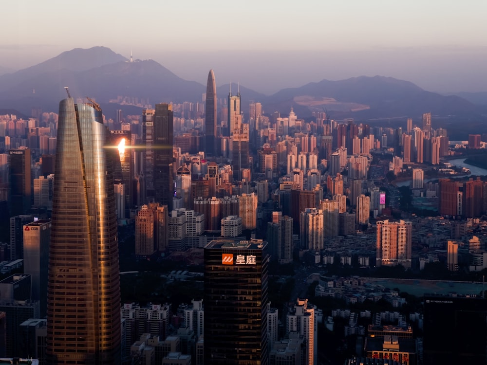 a view of a city with tall buildings and mountains in the background