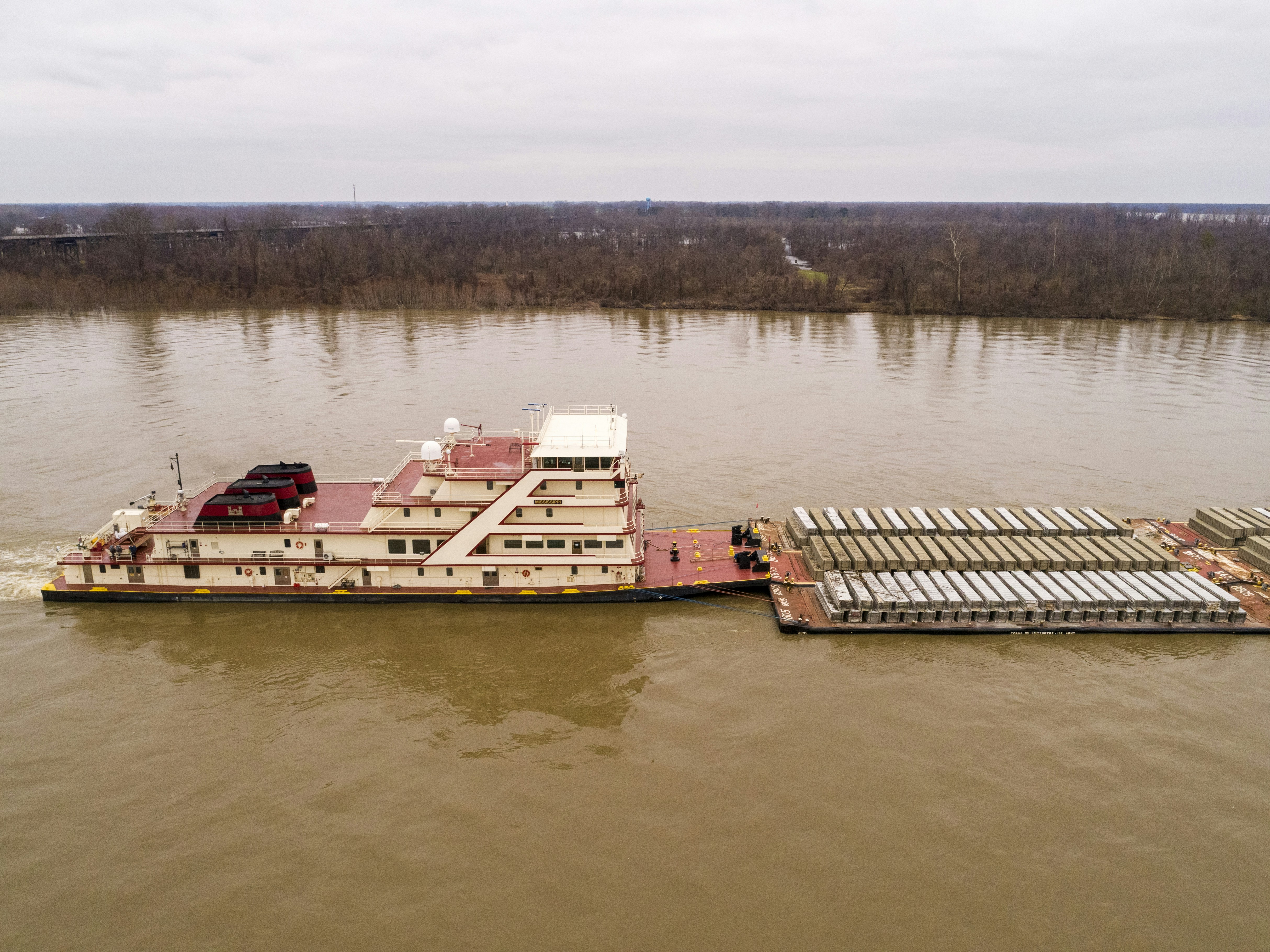 un grand bateau flottant au-dessus d’une rivière à côté d’un quai