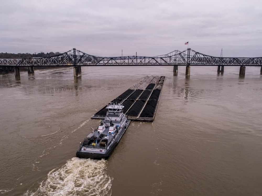 a barge is traveling down the river under a bridge