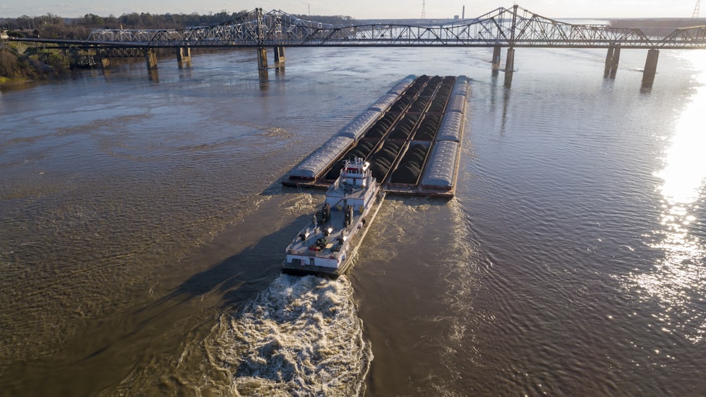 une péniche descendant une rivière à côté d’un pont