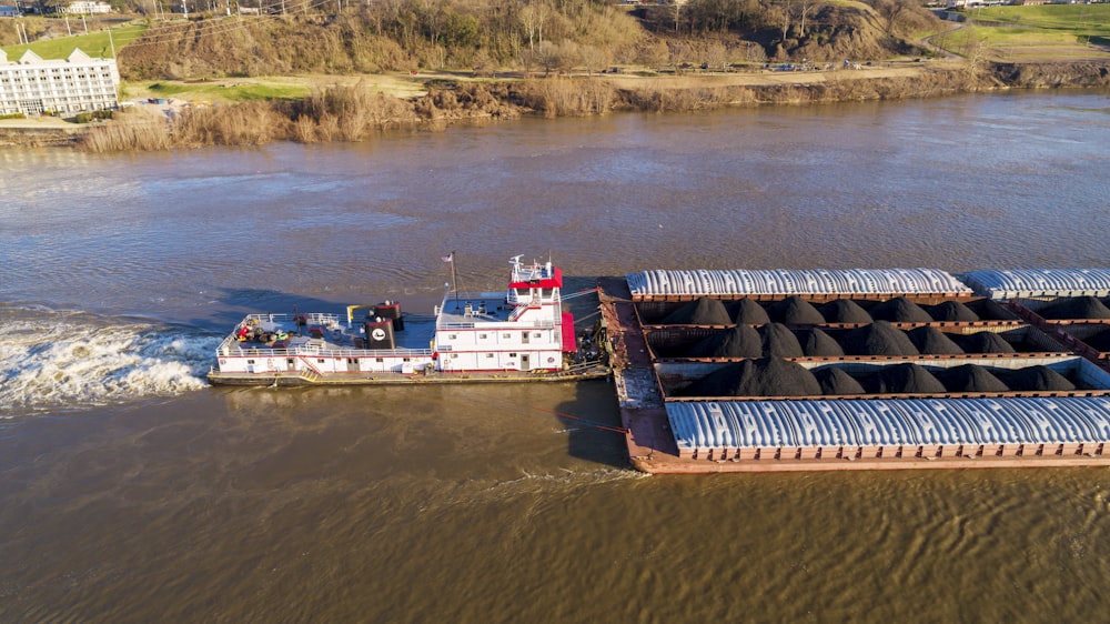 a barge carrying a large amount of coal across a river