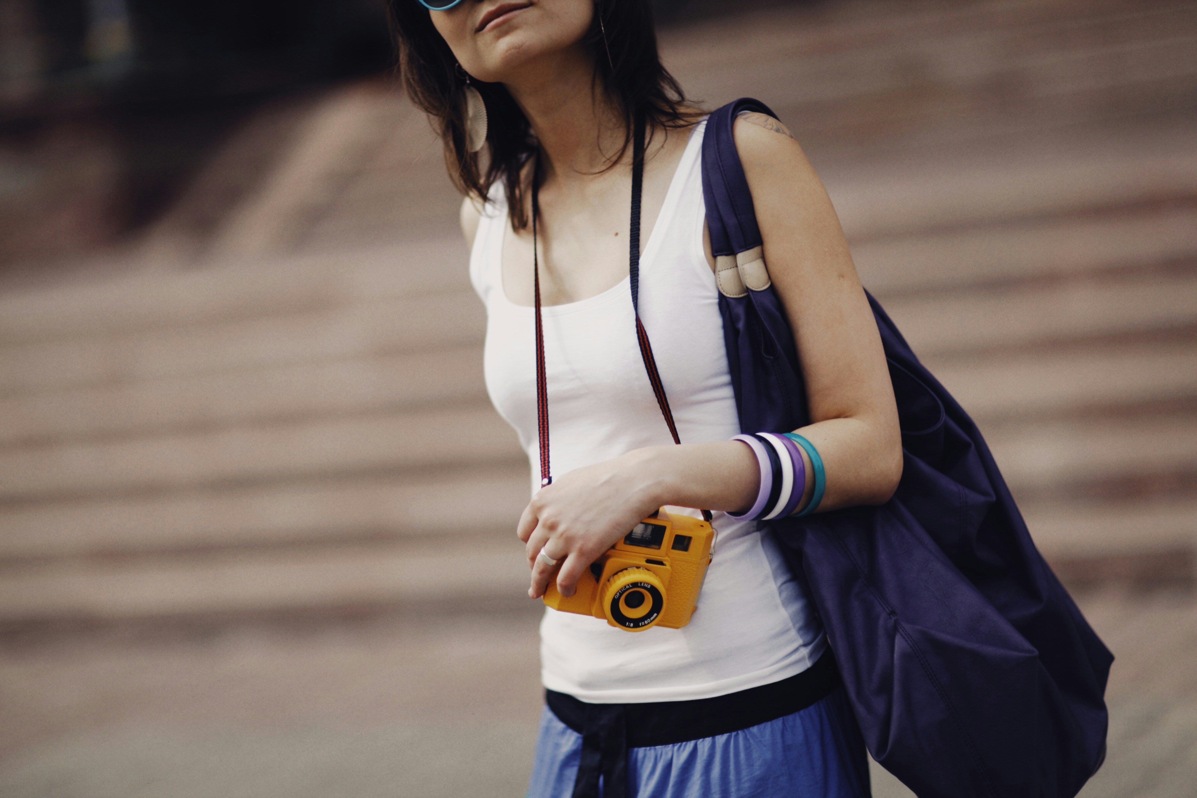 a woman holding a camera and wearing sunglasses