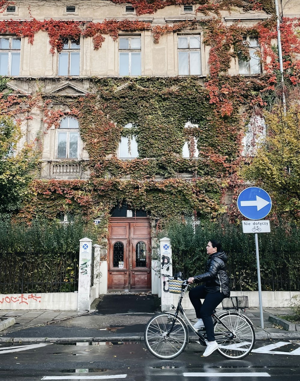 a man riding a bike down a street next to a tall building