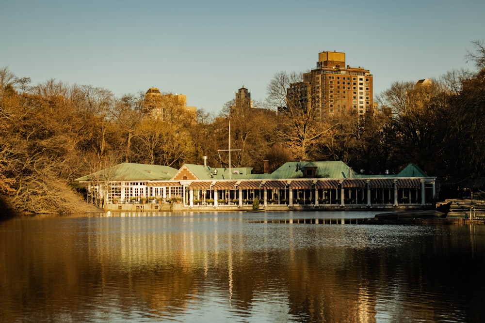 a large building sitting on top of a lake next to a forest