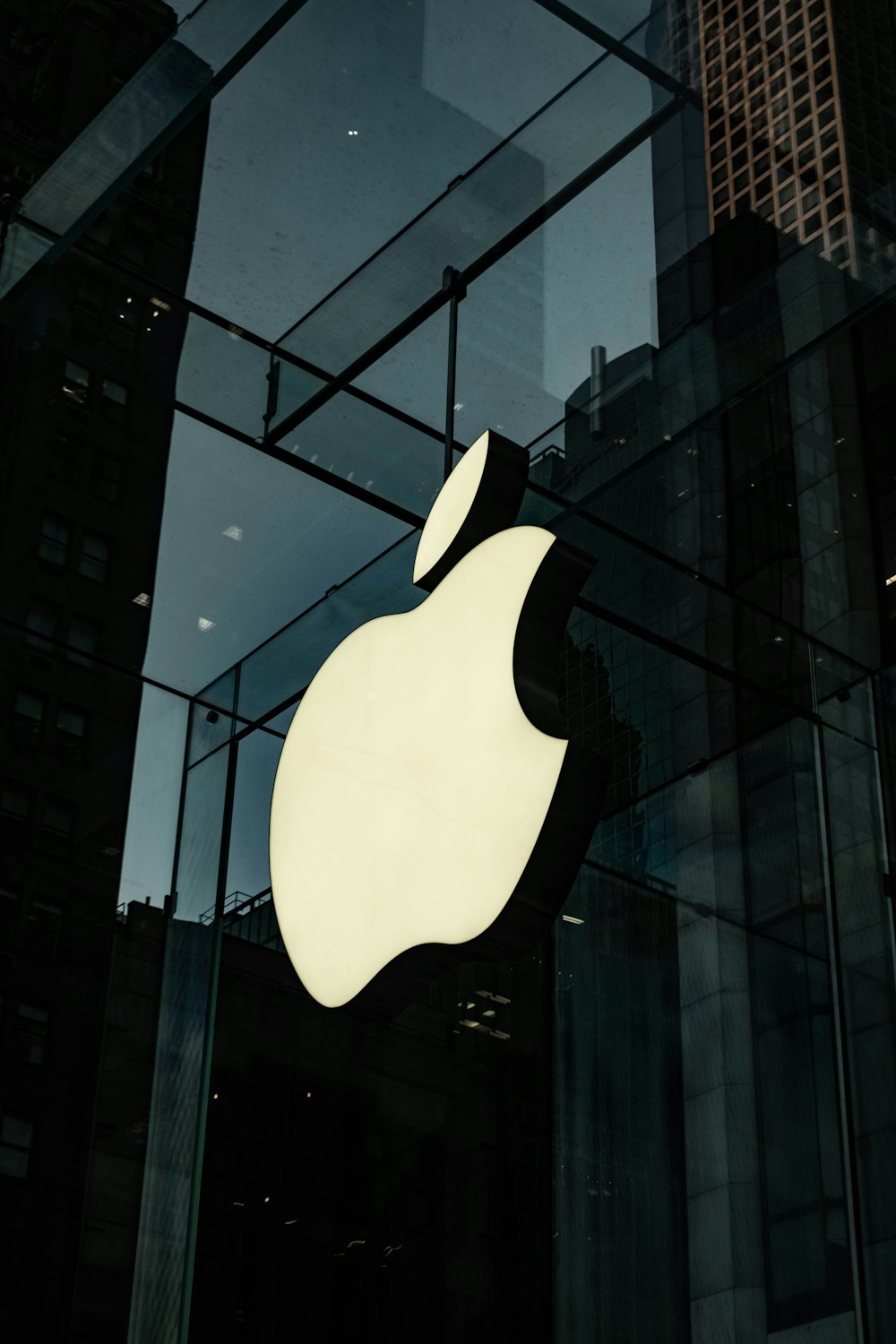um logotipo da maçã é mostrado na frente de um edifício de vidro