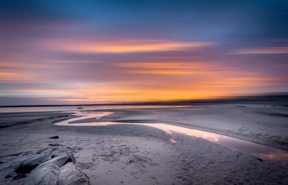 Le soleil se couche sur l’eau sur la plage