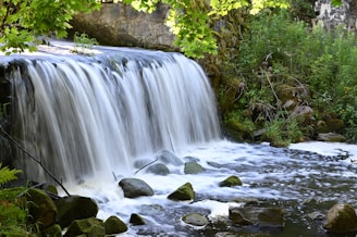 a small waterfall in the middle of a forest