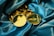 Several gold Ethereum coins are elegantly arranged on a luxurious blue satin fabric. The coins feature the Ethereum logo and the word 'ethereum' prominently engraved, giving a sense of wealth and innovation.