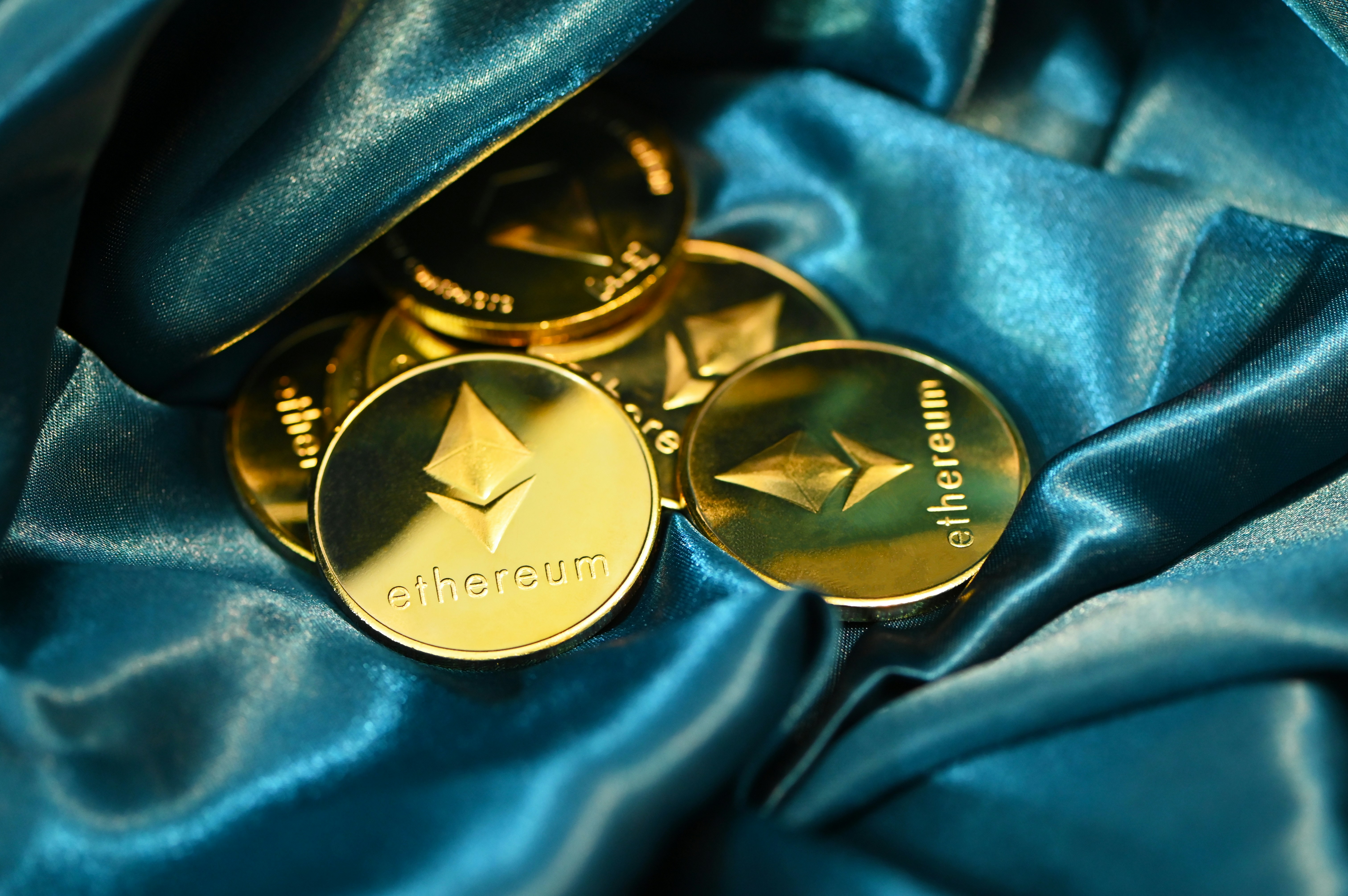 A group of Ethereum coins on a blue fabric