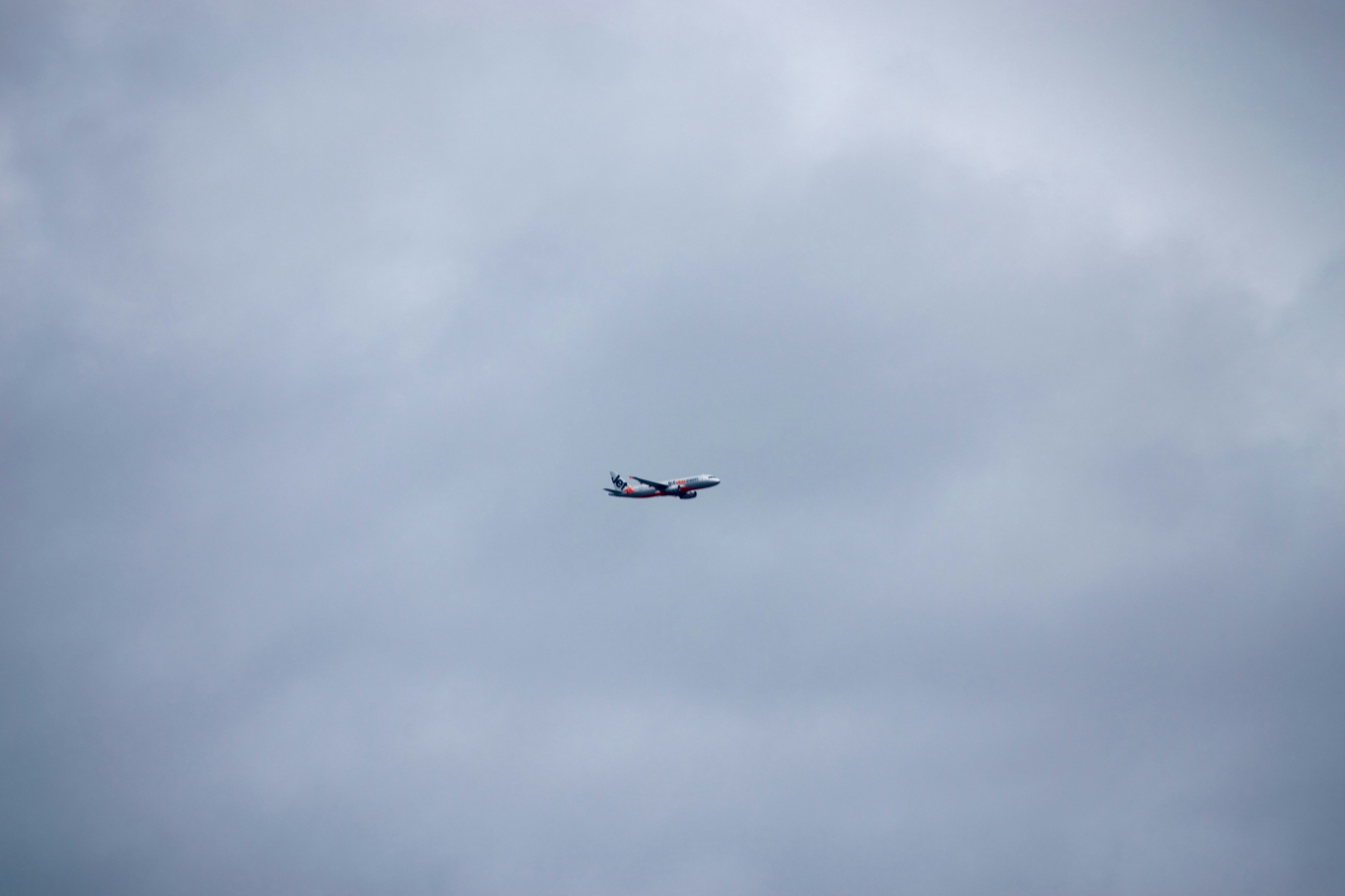 an airplane is flying in the sky on a cloudy day