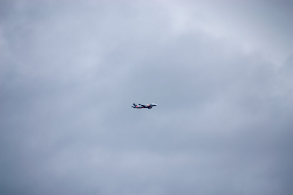 an airplane is flying in the sky on a cloudy day