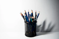 a cup filled with pencils sitting on top of a table