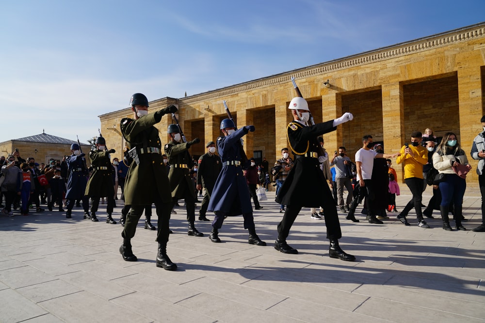 a group of people in uniform dancing in front of a building