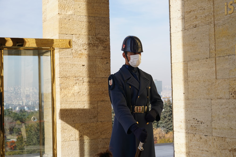 a man wearing a face mask standing in front of a building