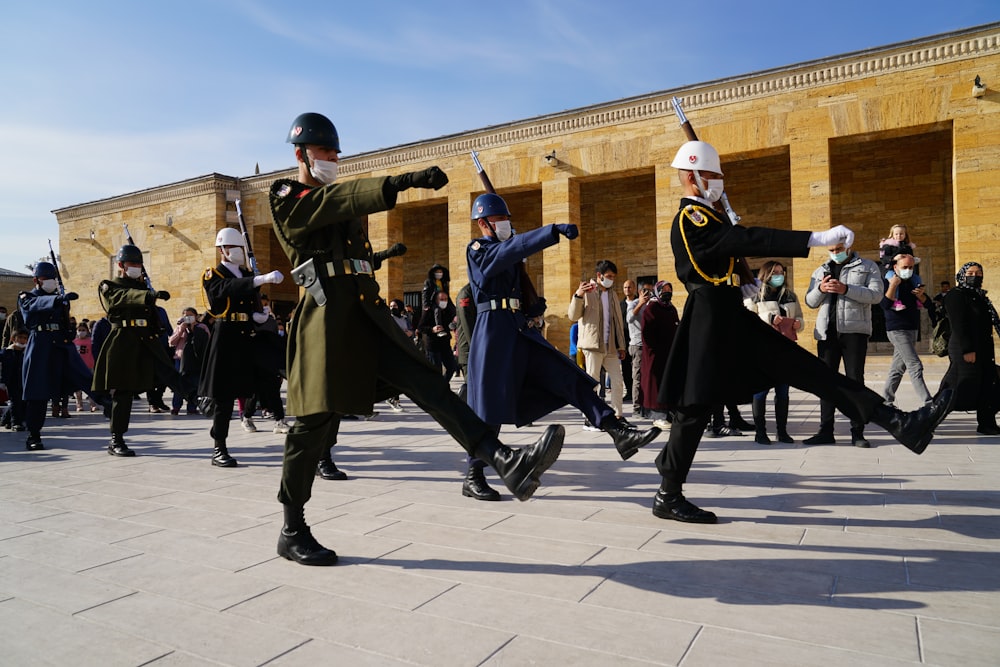 a group of men in uniform dancing in front of a crowd