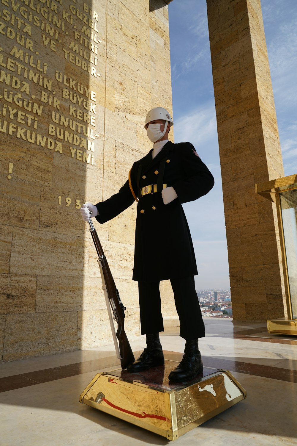 une statue d’un homme en uniforme tenant un fusil