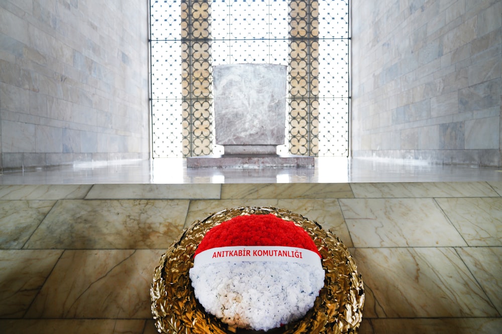 a red and white santa hat sitting on top of a golden nest