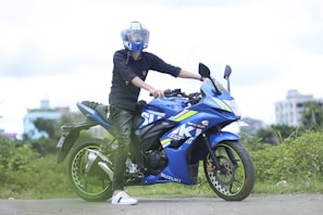 A customer happily test riding a grey Suzuki bike on a quiet Sivakasi road