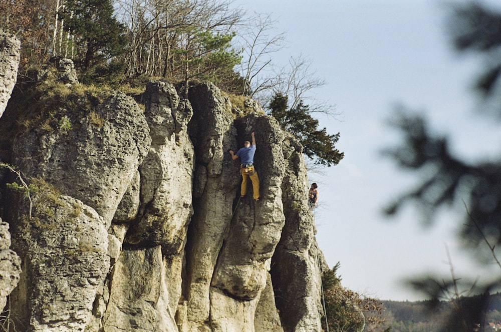 a man climbing up the side of a cliff