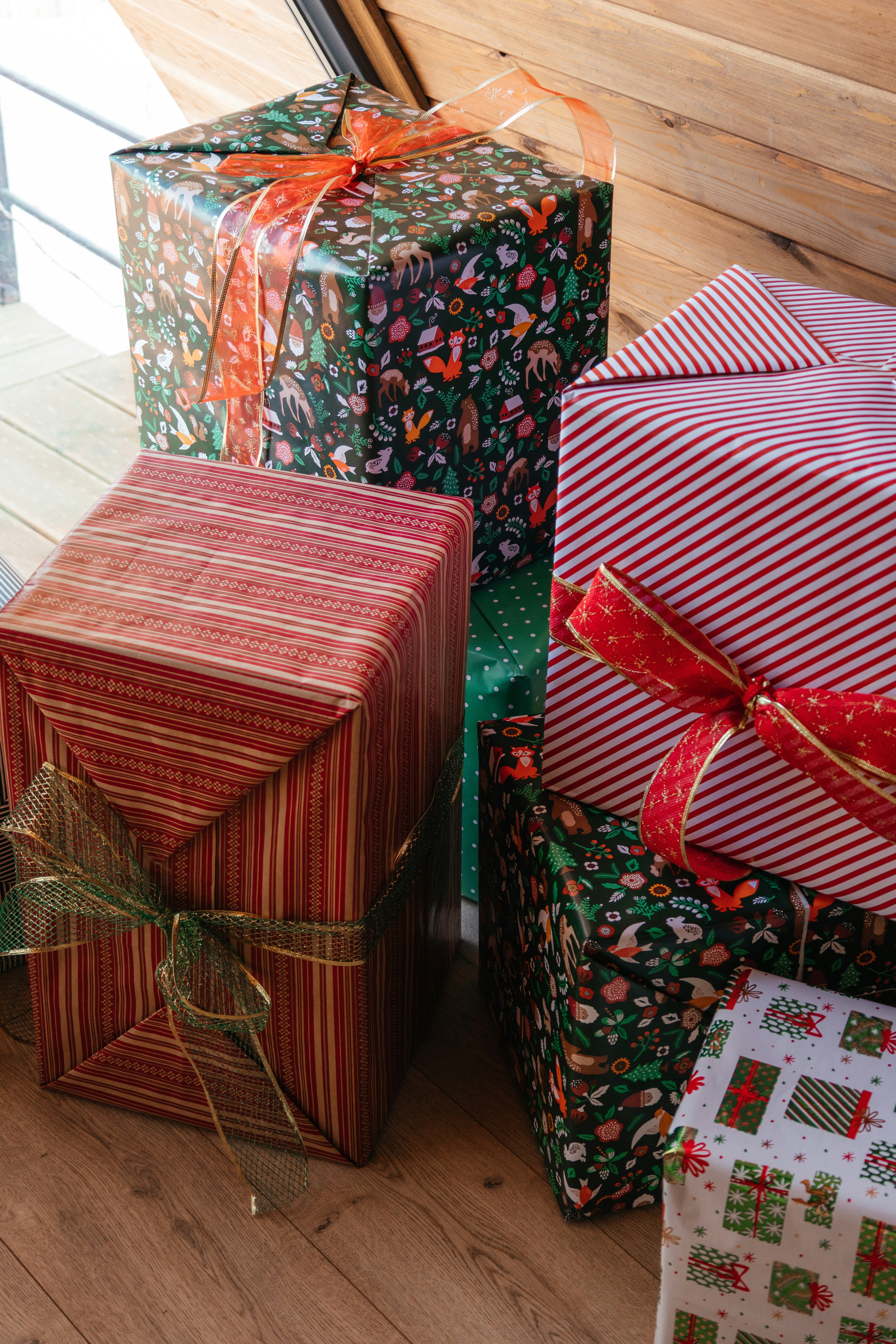 a group of wrapped presents sitting on top of a wooden floor
