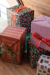 a group of wrapped presents sitting on top of a wooden floor