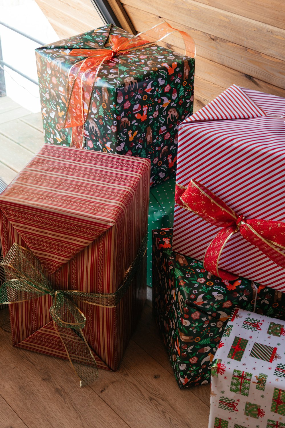 a group of wrapped presents sitting on top of a wooden floor