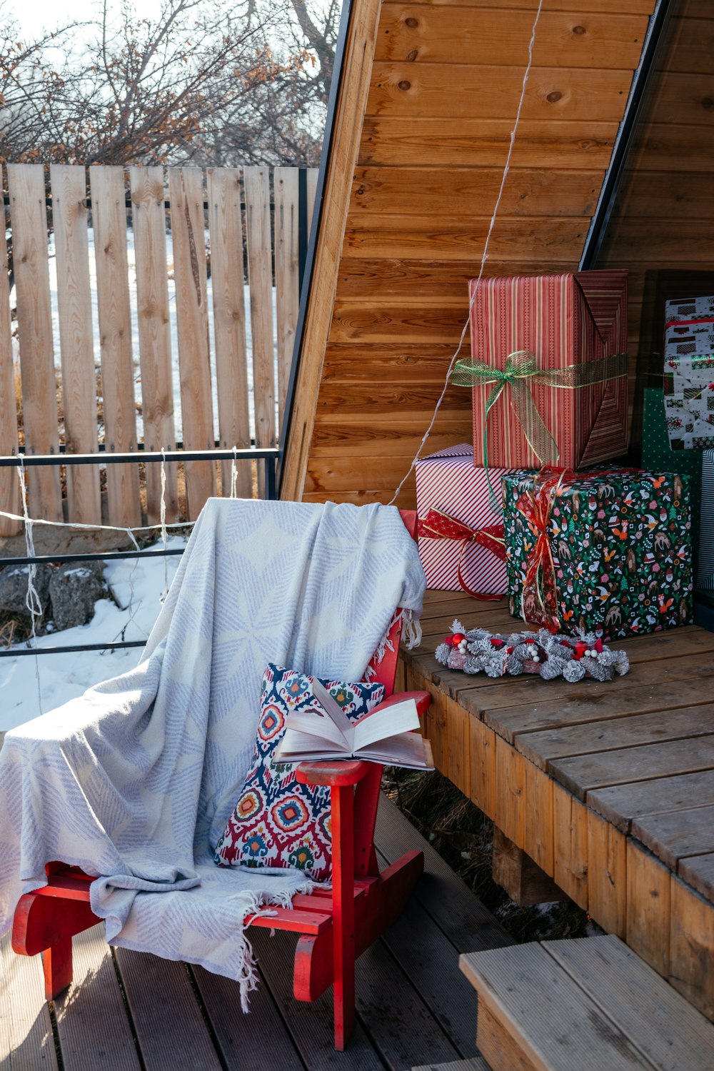 a red chair covered with a blanket and wrapped presents