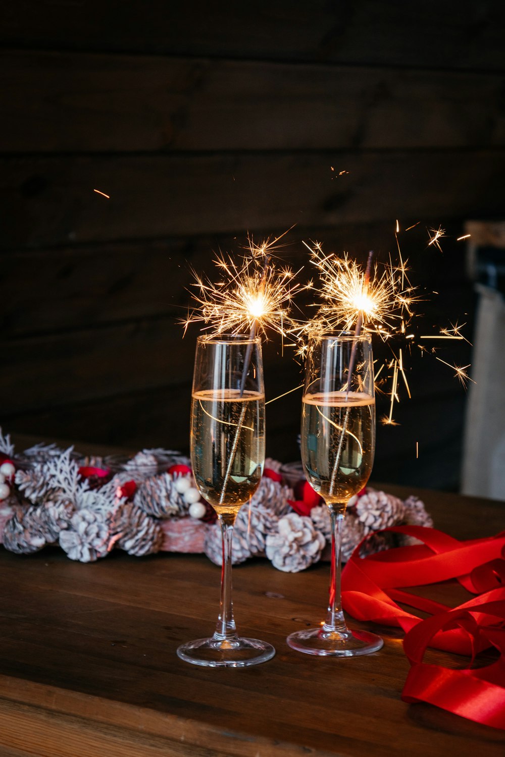 two glasses of champagne with sparklers on a table