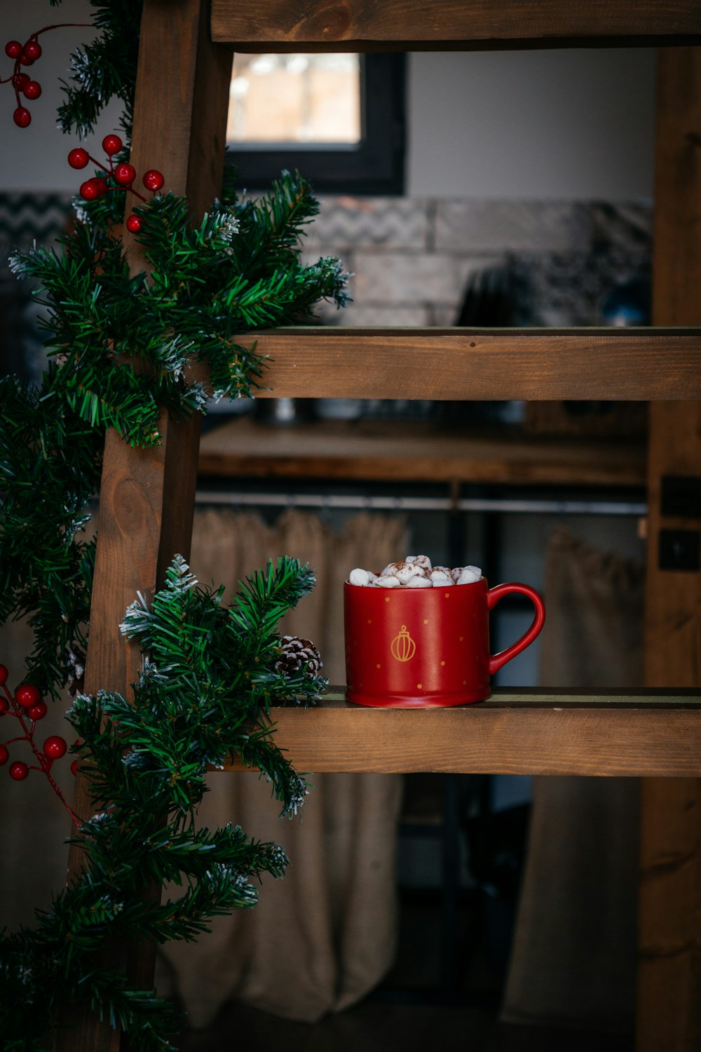 a red cup of coffee sitting on top of a wooden shelf