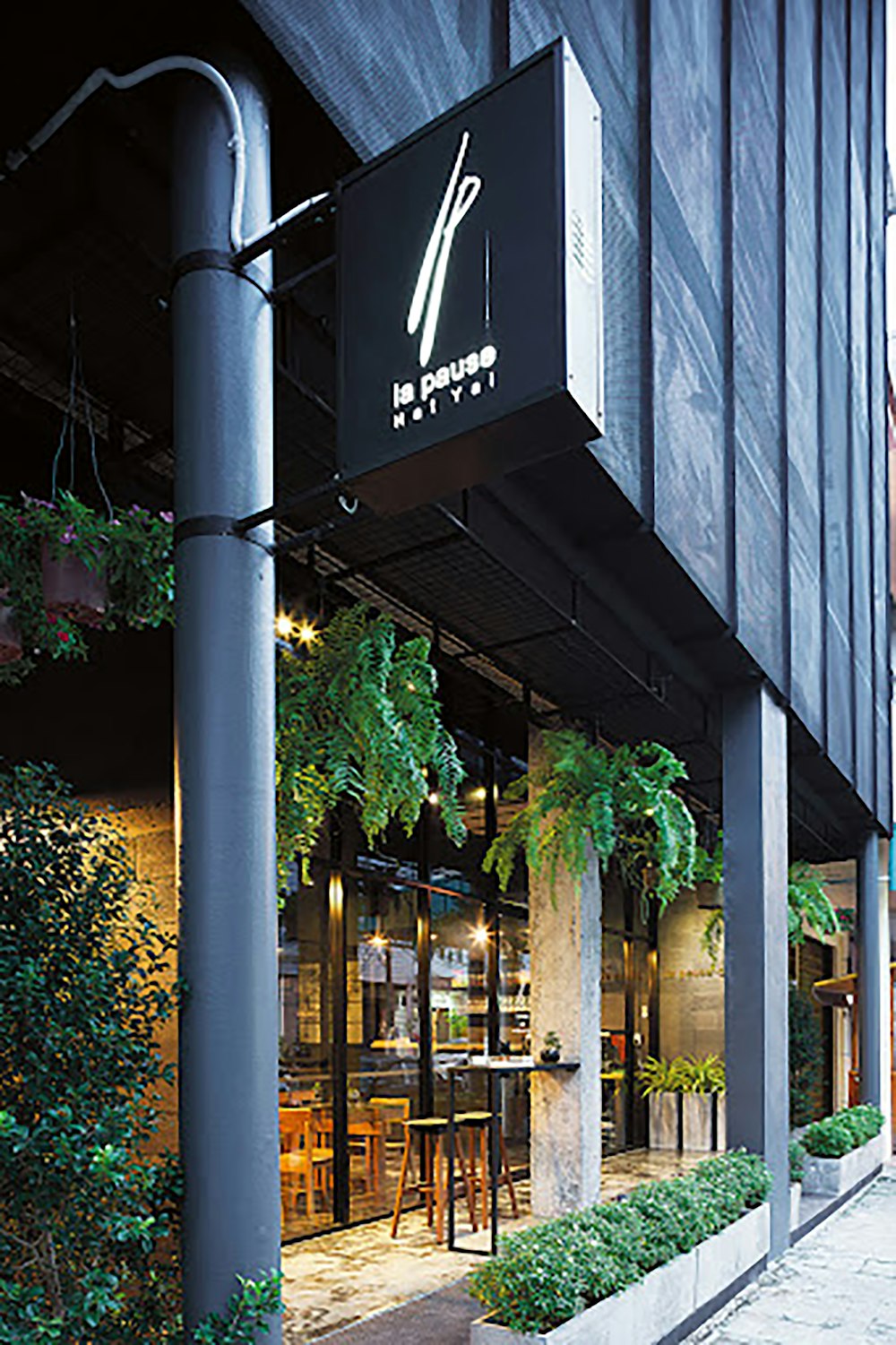 the outside of a restaurant with plants growing out of it