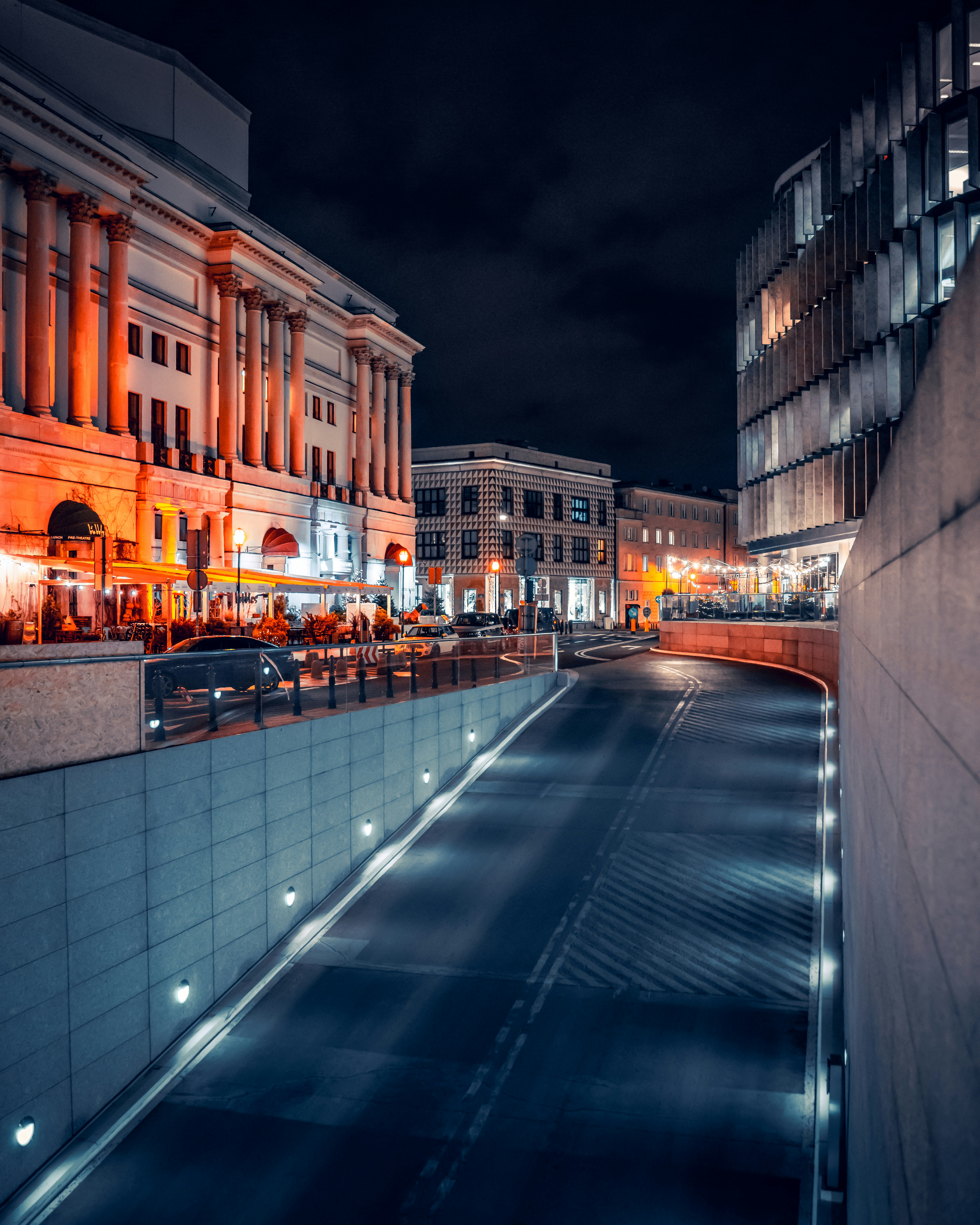 A city street at night with buildings lit up photo – Free Warszawa ...
