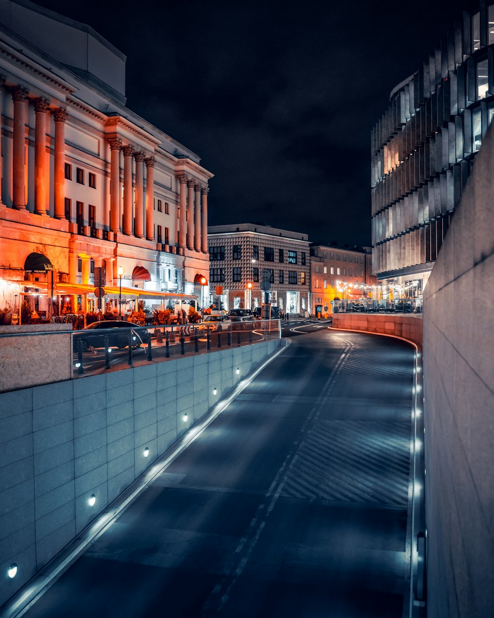 una calle de la ciudad por la noche con edificios iluminados