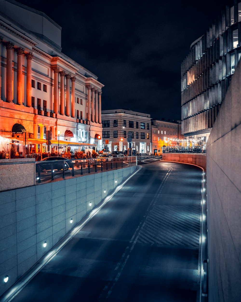 a city street at night with buildings lit up