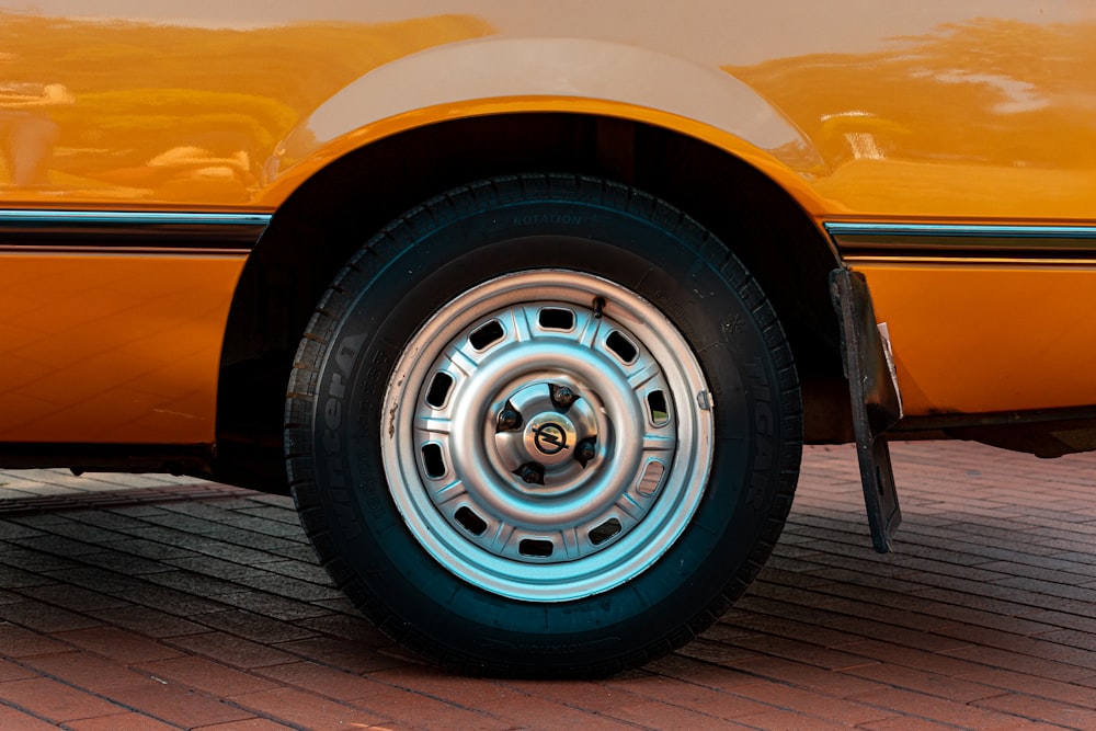 a close up of a tire on a yellow car